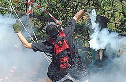 un militante No Tav respinge un lacrimogeno Cs