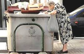 Una pensionata rovista nella spazzatura