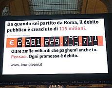 Tabellone sul debito alla stazione ferroviaria Milano Centrale